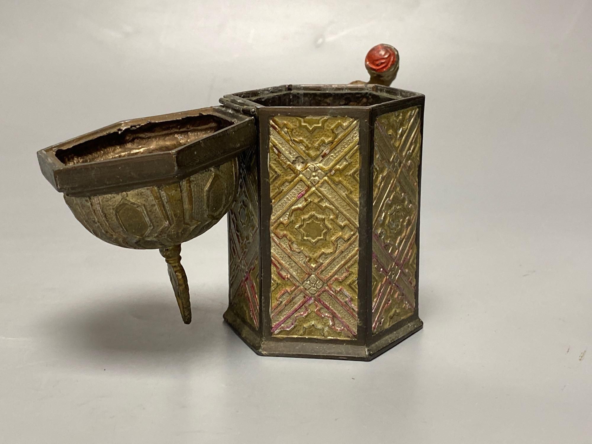 A Bergman style cold painted metal hexagonal casket, with hinged cover, Itinerant labourer alongside, 15cm